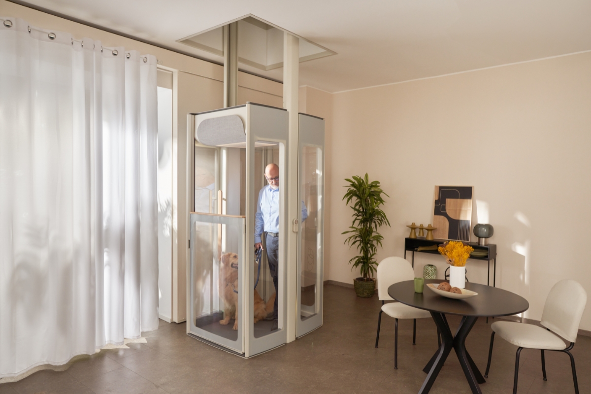 A middle-aged man with his dog on the Uplifts by Stannah home lift.