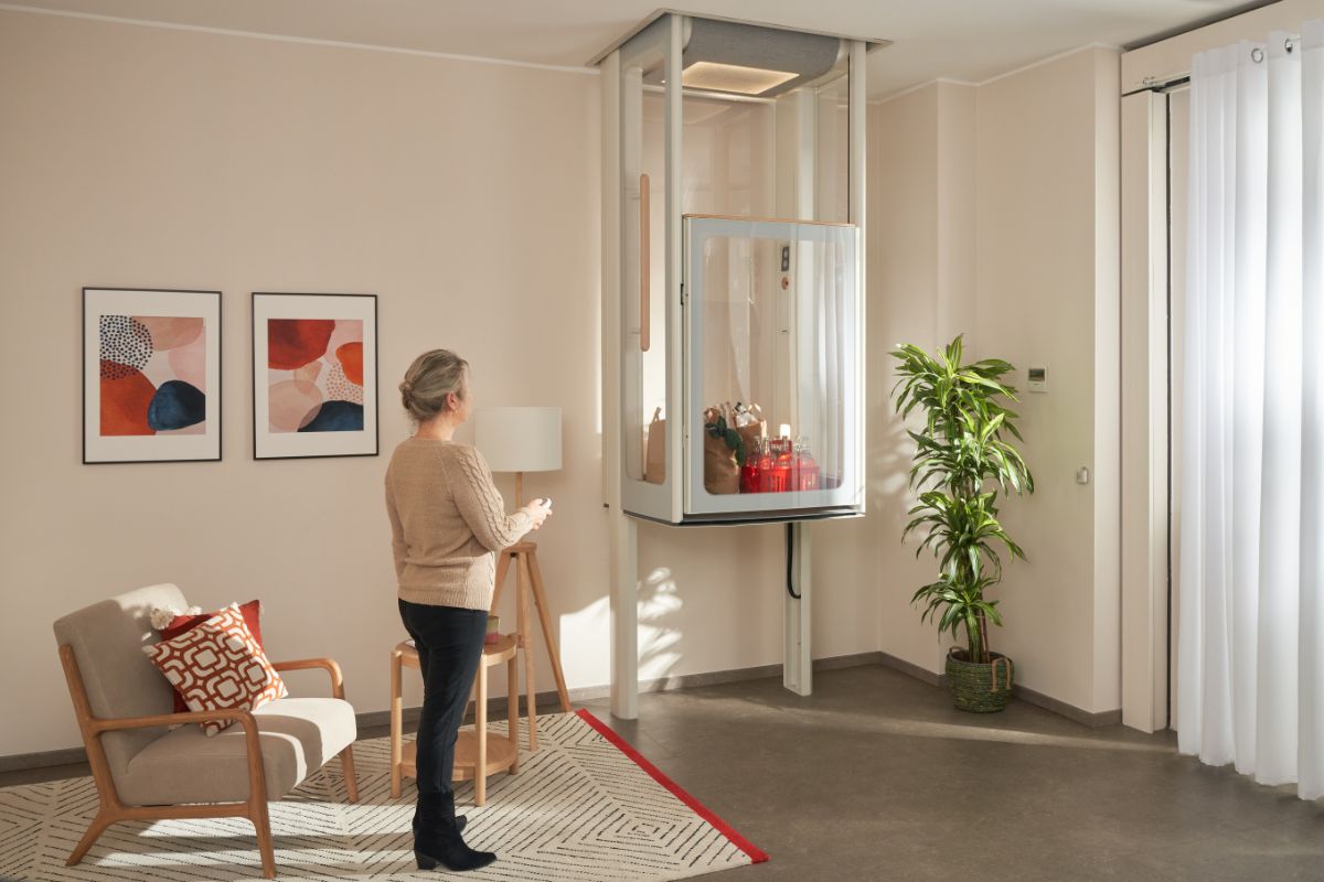 Woman in her living room, lifting the Uplifts S2 with her groceries inside