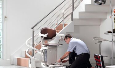 Stannah engineer removing a curved stairlift from a staircase